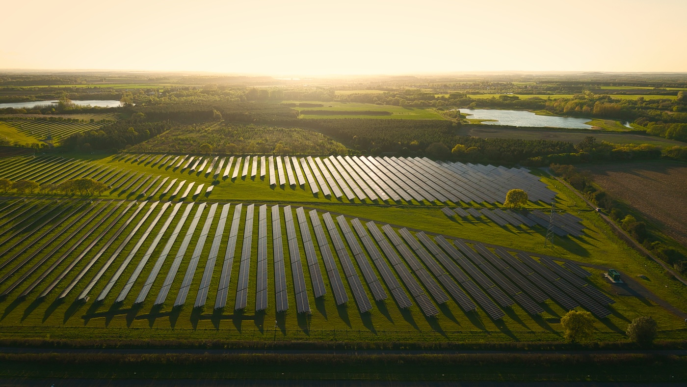 Rows of ground-mounted solar panels across green farmland, showing how solar PV can work on Irish farms through Netzero Group services.